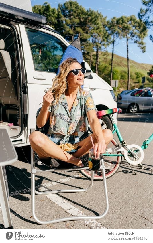 Fröhliche Frau, die einen Saft genießt, während sie im Wohnwagen auf dem Campingplatz sitzt Reise Ausflug Transport Urlaub Abenteuer reisen Sommer Wohnmobil
