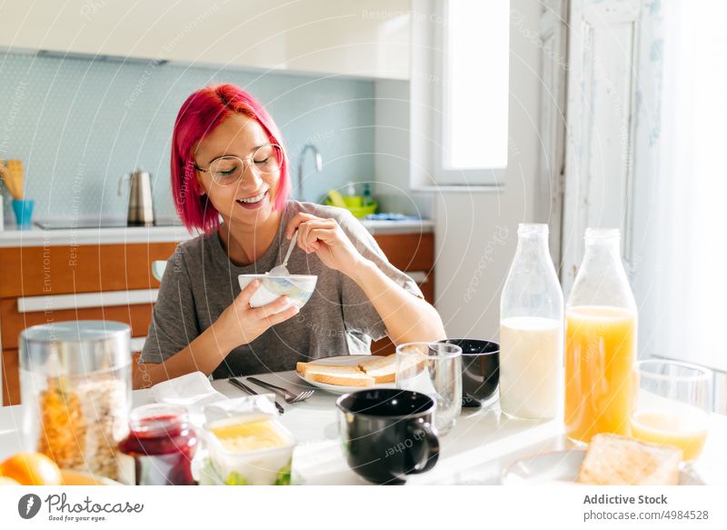 Junge Frau beim gesunden Frühstück zu Hause Gesundheit Morgen heimwärts Lächeln Tisch gemütlich essen Küche Appartement modern jung gefärbtes Haar alternativ