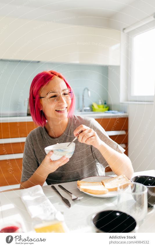Junge Frau beim gesunden Frühstück zu Hause Gesundheit Morgen heimwärts Lächeln Tisch gemütlich essen Küche Appartement modern jung rosa Haare gefärbtes Haar
