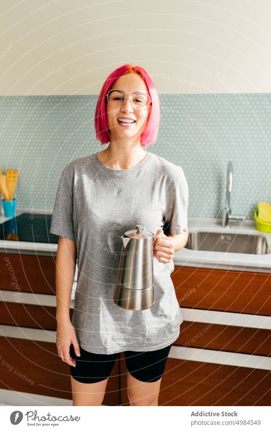 Glückliche junge Frau mit Kaffeemaschine Küche Morgen Frühstück Lächeln vorbereiten trinken modern gefärbtes Haar heiter Lifestyle Getränk Stil trendy Topf