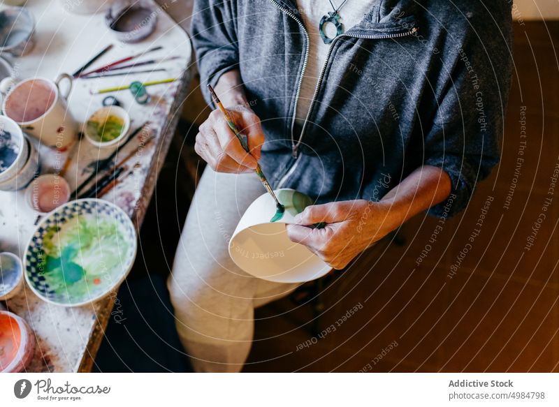 Kunsthandwerkliche Frau beim Bemalen von Töpferwaren in der Werkstatt Handwerkerin Farbe Keramik Kunstgewerbler Basteln kreieren Schalen & Schüsseln