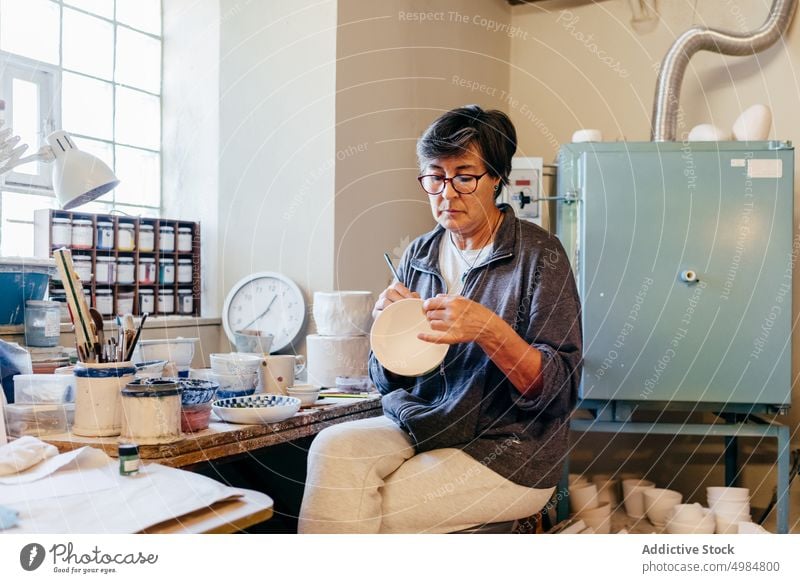 Handwerklich geschickte Frau beim Bemalen von Töpferwaren in der Werkstatt Handwerkerin Farbe Keramik Kunstgewerbler Basteln kreieren Schalen & Schüsseln