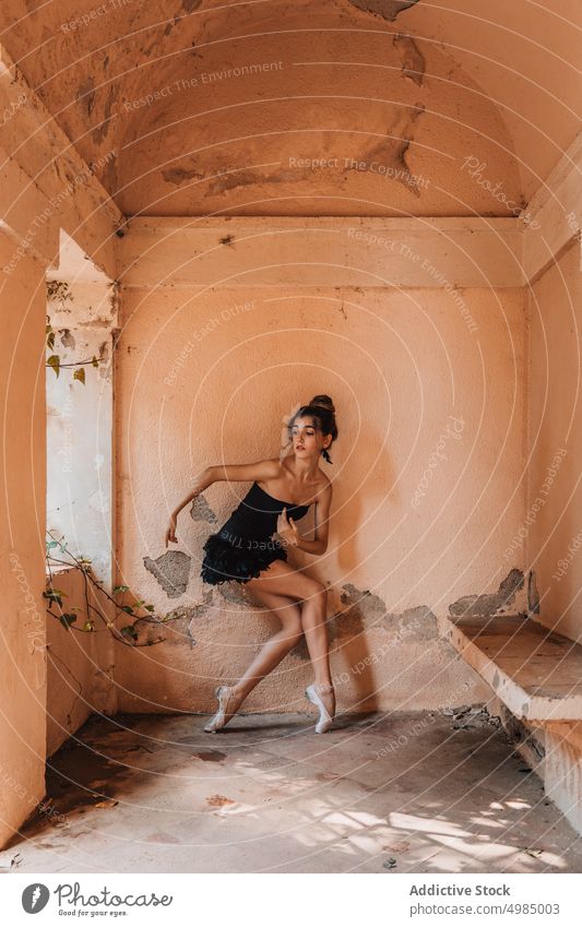 Junge Ballerina posiert mit einem schwarzen Kleid Balletttänzer Tänzer jung schön Tanzen Schuhe Innenbereich Frau modern posierend Klassik auf Zehenspitzen