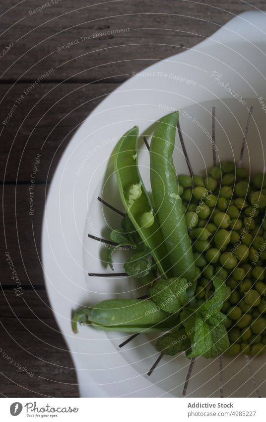 Schüssel mit Erbsen und Minze abtropfen lassen Schalen & Schüsseln Hülsen frisch grün Blätter rustikal Ackerbau Wachstum Pflanze reif organisch Snack Samen