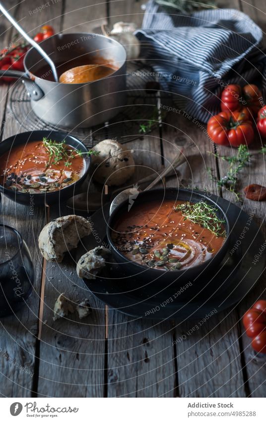 Cremige Tomatensuppe mit getrockneten Aprikosen Suppe Sahne serviert Saatgut organisch Brötchen lecker Veganer Garnierung Brot Feinschmecker Speise Abendessen