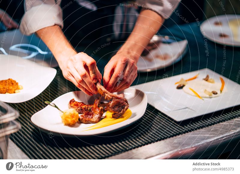 Crop Man serviert Fleisch auf einem Teller Küchenchef dienen anspruchsvoll Mahlzeit einrichten Gastronomie Garnierung Reichtum professionell kulinarisch