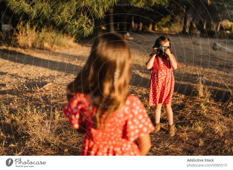Mädchen, das seine kleine Schwester auf einer Wiese fotografiert Freundschaft fotografierend Sommer Feld Natur Fotokamera Fotografie schön Technik & Technologie
