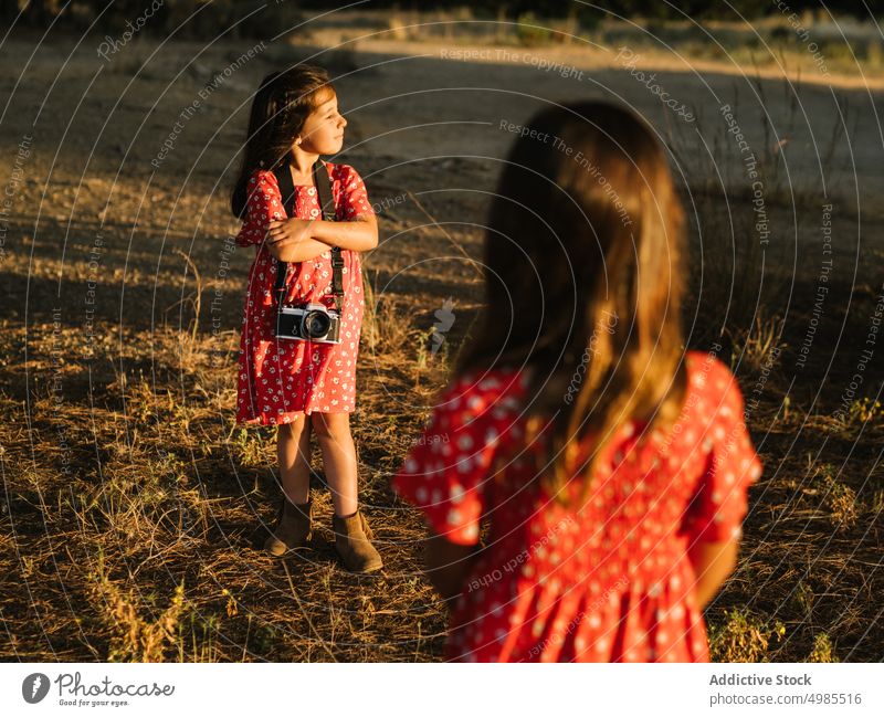 Mädchen, das seine kleine Schwester auf einer Wiese fotografiert Freundschaft fotografierend Sommer Feld Natur Fotokamera Fotografie schön Technik & Technologie