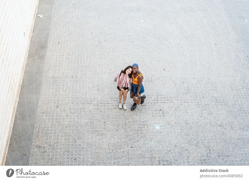 Stilvolles multiethnisches Paar von lesbischen Frauen in der Stadt cool urban lgbt Lächeln heiter positiv gleichgeschlechtlich Freundin Straße