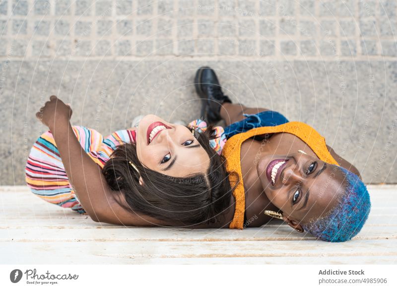 Multirassisches Paar von stilvollen lesbischen Frauen in der Stadt Stil Freundin trendy Partnerschaft Zusammensein lgbt gleichgeschlechtlich multiethnisch