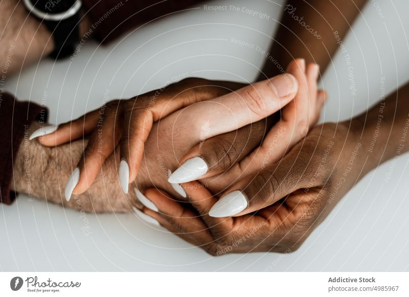Ein multiethnisches Paar, das sich an den Händen hält Liebe Händchenhalten Zusammensein Partnerschaft sanft Pflege weich Zuneigung Termin & Datum berühren