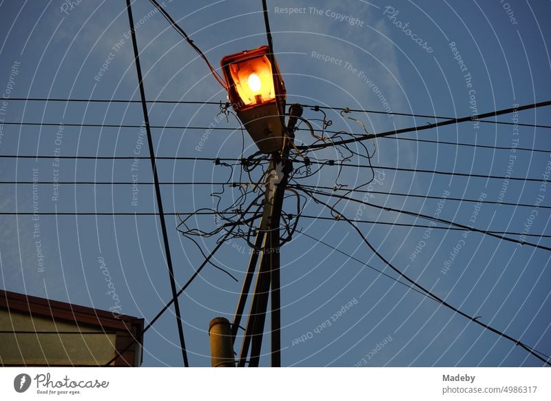 Stromleitungen mit Straßenbeleuchtung an einem Leitungsmast am Abend in Adapazari in der Provinz Sakarya in der Türkei straßenbeleuchtung strommast stromleitung