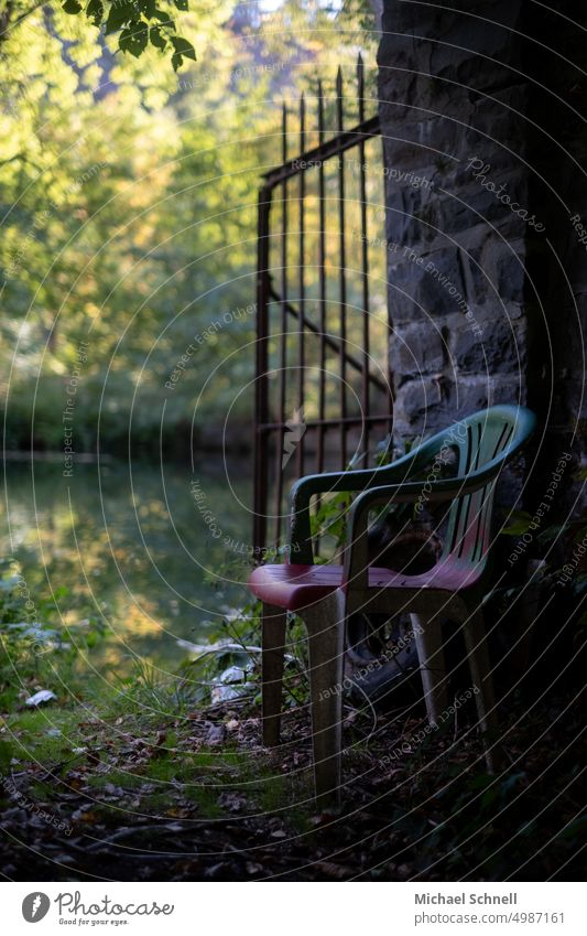 Einsamer, bunter Plastikstuhl an einem Fluss (Lenne, Nordrhein-Westfalen, Deutschland) Stuhl sitzen Sitzgelegenheit Ruhe entspannung leer verlassen