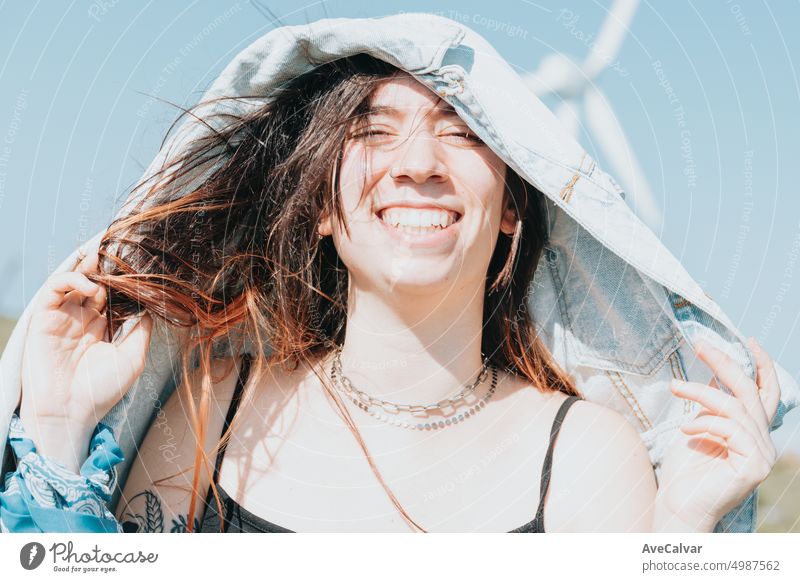 Close up Porträt einer glücklichen jungen Frau bedeckt Kopf mit Jacke sonnigen Tag 20s Lächeln Glück plaudernd Auge freundlich Reise freudig Lachen zuhören