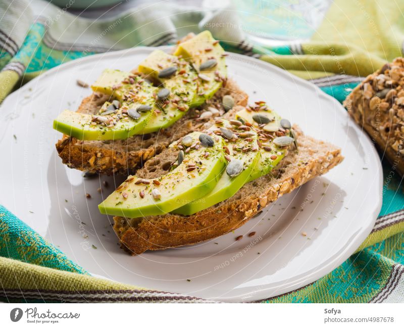 Avocado-Sandwich als gesunder Snack mit Kernen Zuprosten Belegtes Brot Scheibe Lebensmittel Gemüse Gesundheit Müsli Vollkorn Saatgut Kürbis flex essen