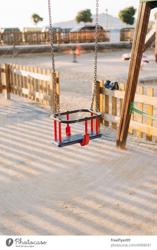 Detail einer Kleinkinderschaukel auf einem Kinderspielplatz Spielplatz leer niemand pendeln Textfreiraum Kunststoff sicher Gefahr ruhig Kulisse bunt Objekt