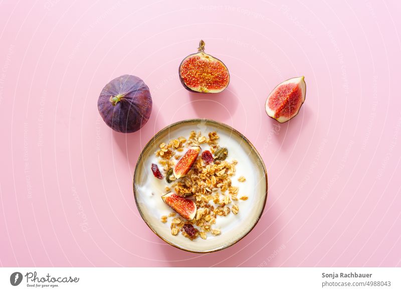Eine Schüssel Joghurt, Granola und frische Feigen auf einem rosa Hintergrund. Frühstück. Müsli modern Foodfotografie Gesundheit Diät süß Ernährung Vitamin