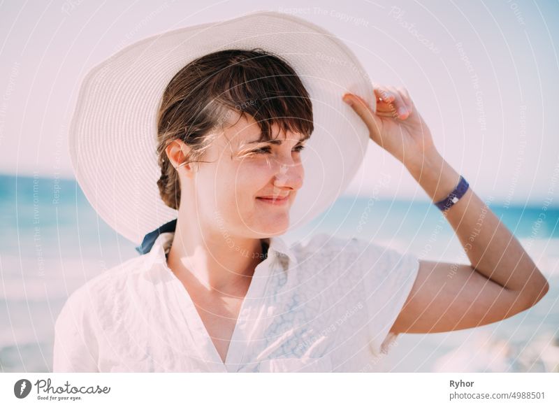 Junge kaukasische Frau in Sommerhut Posing in der Nähe von Meer Strand. Nahaufnahme Porträt. Urlaub am Meer Ozean Strand authentisch schön Schönheit Kaukasier