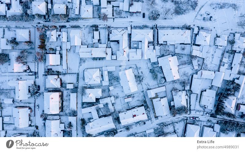 Luftaufnahme von oben auf eine verschneite Stadtlandschaft, Aussehen der Stadt im Winter. Antenne Architektur Dachboden Gebäude Großstadt Stadtbild Klima kalt