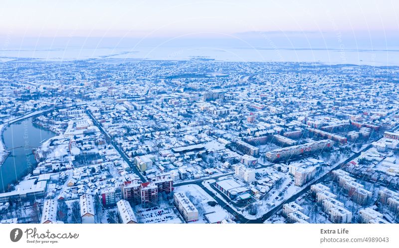 Blick von oben auf die verschneite Stadtlandschaft, Aussehen der Stadt im Winter. Antenne architektonisch Dachboden Brücke Gebäude Großstadt Stadtbild Klima