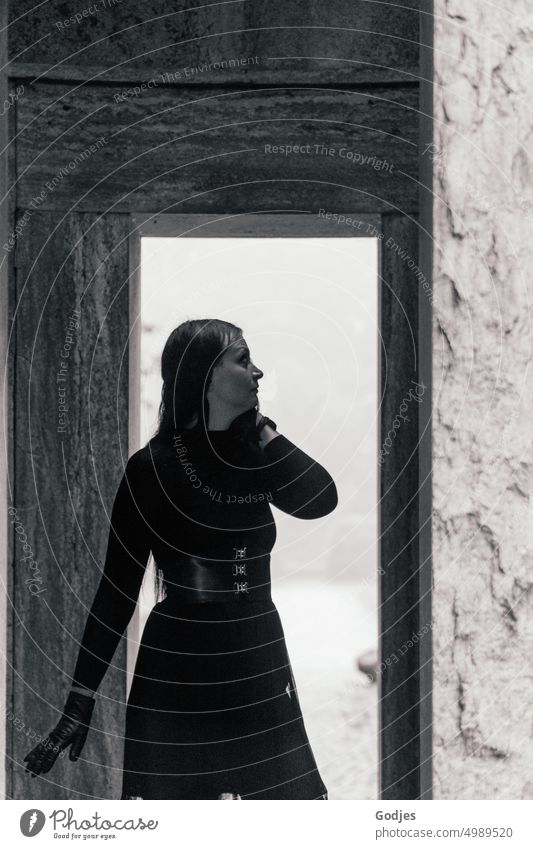 [HH Unnamed Road] posierende Frau in schwarzer Kleidung im Lichtschein eines Durchgangs schön jung Person Model Dame brünett Schwarzweißfoto elegant Korsage