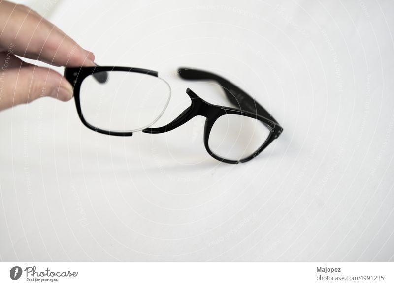 Kaukasische menschliche Hand, die ein zerbrochenes Brillengestell hält. Ansicht anhaben Design sehen lesen Kunststoff Rahmen Augenlicht Stil modern optisch
