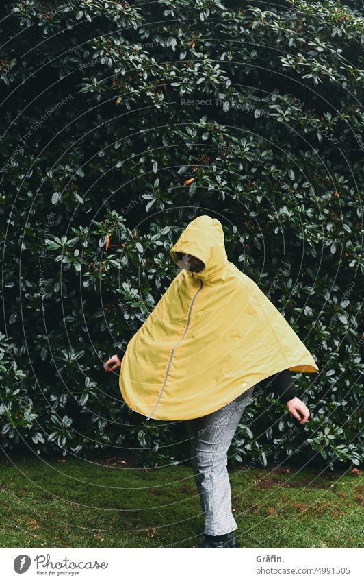 [HH Unnamed Road] Frau in gelber Regenjacke dreht sich im Kreis im Regen drehen regnerisch Außenaufnahme Person Einzelperson schlechtes Wetter Park Grünanlage