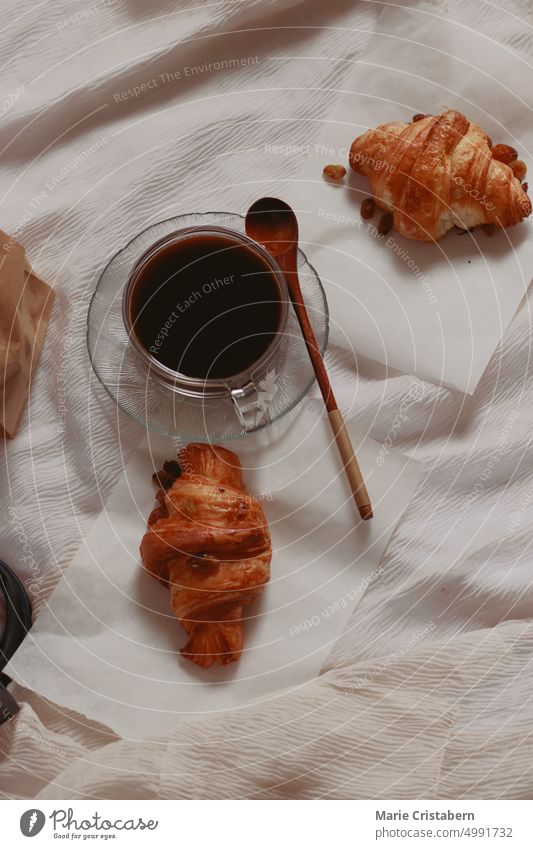 Vertikale Draufsicht auf frisch gebackene Croissants und schwarzen Kaffee für ein einfaches französisches Frühstück Einfachheit Herbst Wohlbefinden