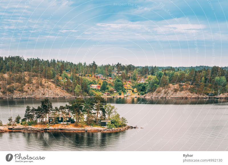 Schweden. Viele schöne schwedische Holzblockhäuser Häuser auf Rocky Island Küste im Sommer Tag. See oder Fluss Landschaft Schwedisch Appartement Inselgruppe