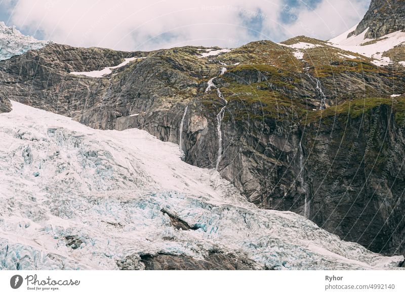 Jostedalsbreen National Park, Norwegen. Close Up View of Melting Ice and Snow, Small Waterfall On Boyabreen Glacier In Spring Sunny Day. Berühmtes norwegisches Wahrzeichen und beliebtes Reiseziel. Nahaufnahme