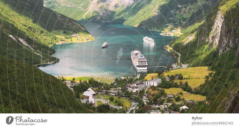 Geirangerfjord, Norwegen. Luftaufnahme von Geiranger in Geirangerfjorden im Sommer Tag. Touristische Schiff Fähre Boot Liner vertäut in der Nähe von Geiranger. Berühmtes norwegisches Wahrzeichen und beliebtes Reiseziel