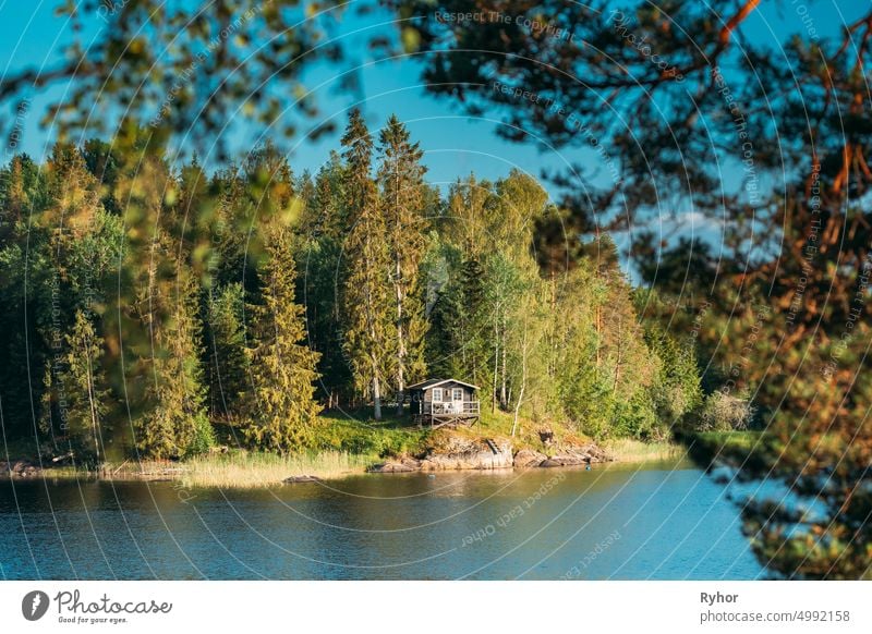 Schweden. Schöne schwedische Holzblockhaus Haus auf Rocky Island Küste im Sommer sonnigen Abend. See oder Fluss Landschaft Schwedisch Appartement Architektur