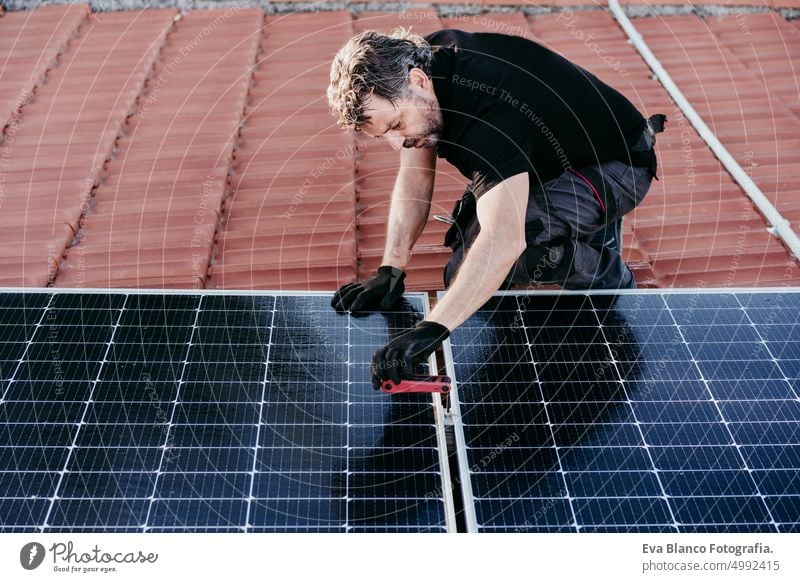 reifen Techniker Mann Montage von Sonnenkollektoren auf Hausdach für den Eigenverbrauch Energie. Erneuerbare Energien Konzept Ökostrom Dach Photovoltaik