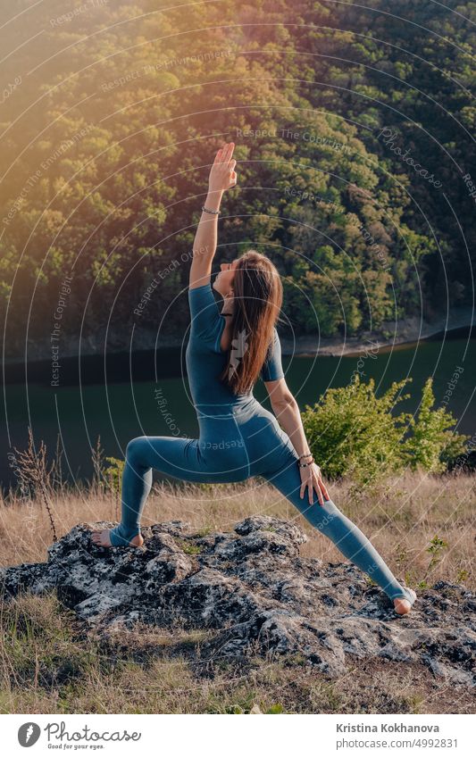 Yogi Frau auf dem Gipfel eines hohen Berges macht Yoga-Praxis mit tiefer Atmung. Stretching Körper. Wilde Natur, freier Mensch. Freiheit, gesunder Lebensstil, tägliche Praxis.