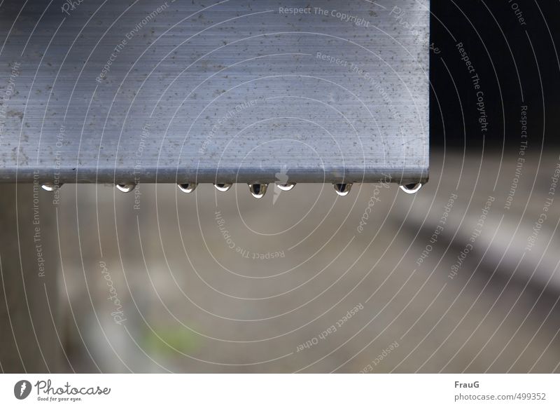 8 Tropfen an Aluminium Metall Wasser glänzend grau Wassertropfen nass hängen Regenwasser Farbfoto Außenaufnahme Textfreiraum unten Tag Schwache Tiefenschärfe