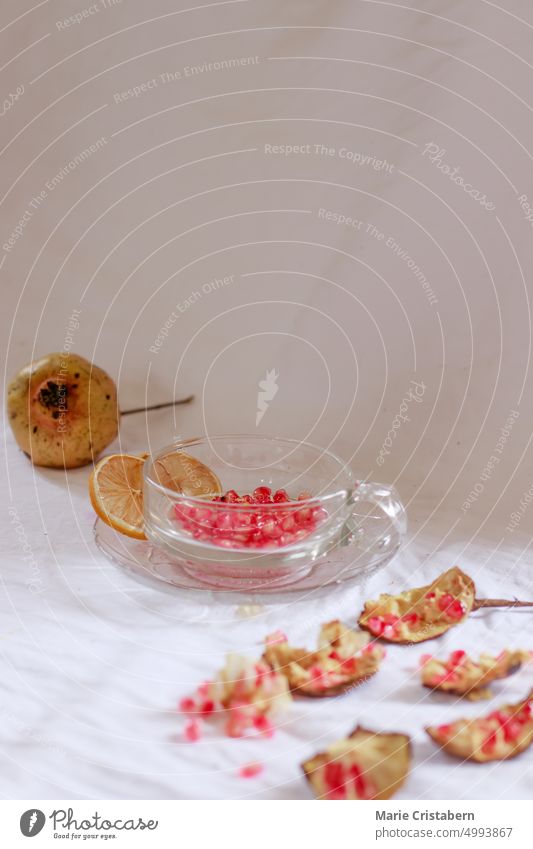 Vertikaler Schuss von Granatapfelkernen auf einen Glasbecher, um frischen Fruchtsaft für ein erfrischendes Sommergetränk herzustellen Erfrischung Wohlbefinden