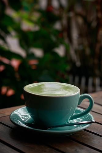 Vertikale Aufnahme einer Tasse Matcha Latte an einem kalten Herbsttag keine Menschen Kantine trinken Heißgetränk Café Kaffeehaus Textfreiraum blau