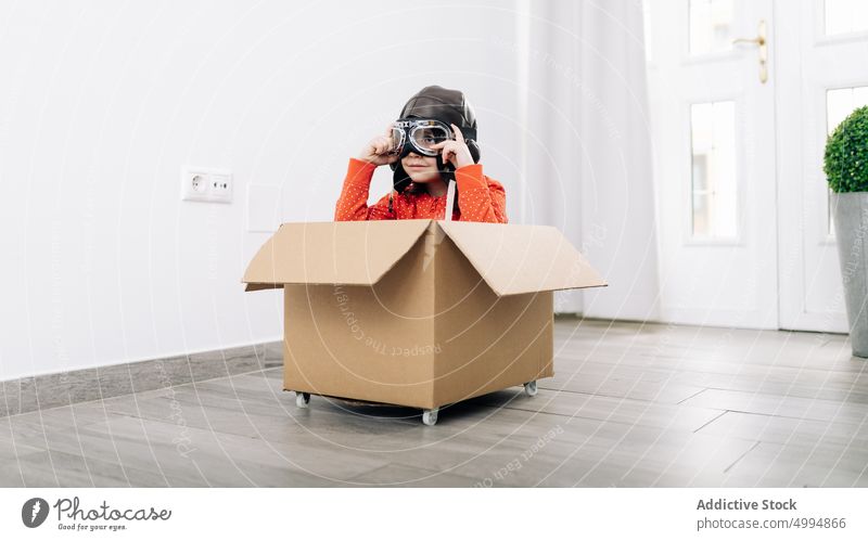 Kind mit Pilotenhelm und Schutzbrille träumt von der Zukunft Flieger Schutzhelm so tun, als ob verträumt Vorstellungskraft nachdenklich Kindheit Schachtel