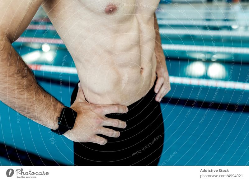 Crop Schwimmer mit Sixpack abs gegen Pool Unterleib muskulös Hand an der Hüfte sportlich Körper nackter Torso SMA