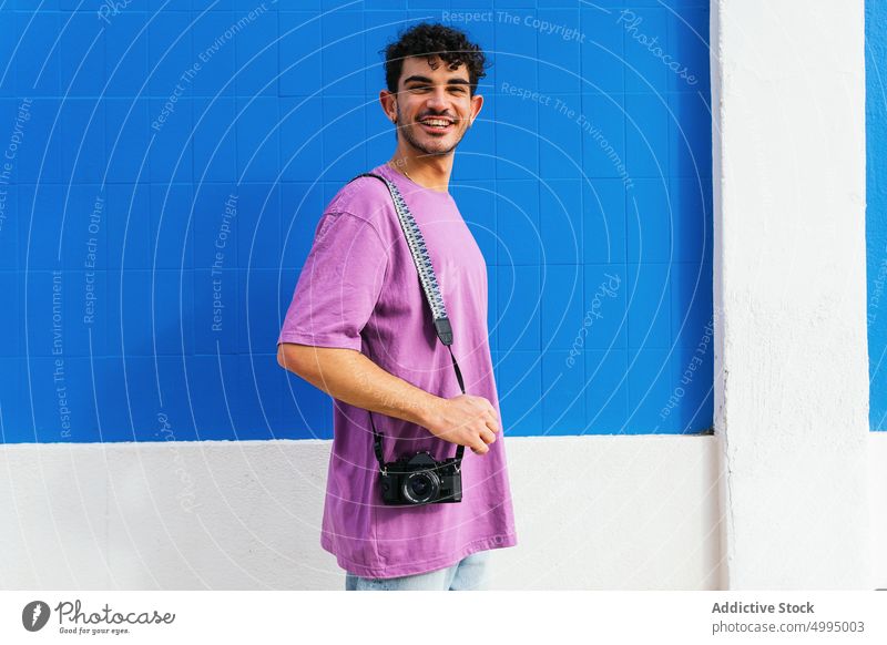 Glücklicher Mann, der vor einem modernen Gebäude fotografiert fotografieren Fotograf Straße Fotoapparat schießen urban Hobby männlich jung hispanisch Lächeln