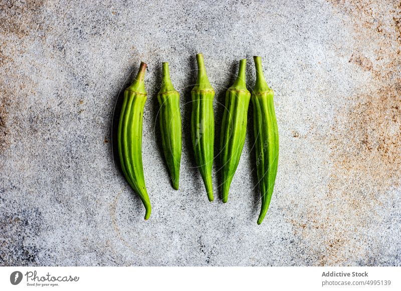 Rohes Bambusholz im Betonhintergrund bamia bamya Koch Essen zubereiten Küche Lebensmittel grün Gesundheit okra organisch roh Tisch Veganer Tablett Gemüse