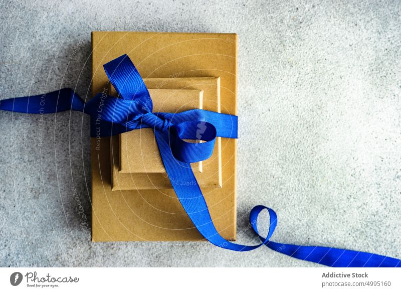 Weihnachtsgeschenkbox mit blauem Band Hintergrund Kasten Postkarte Weihnachten festlich Geschenk Feiertag präsentieren Bändchen rustikal Stapel gestapelt Tag
