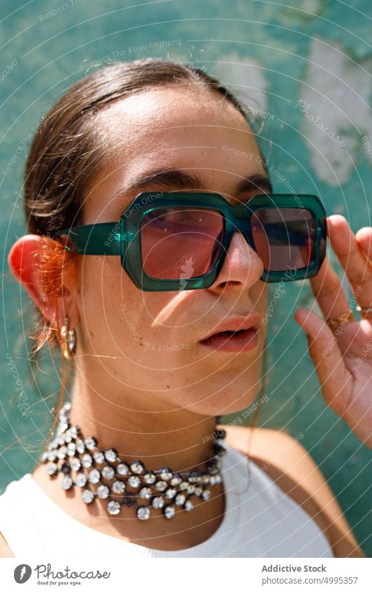 Selbstbewusste ethnische stilvolle Dame schaut in die Kamera im Sonnenlicht Frau Sonnenbrille Mode Stil selbstbewusst Porträt Model ausrichten selbstsicher