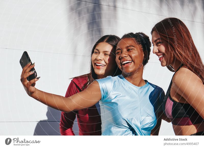 Begeisterte, vielseitige junge Sportlerinnen machen ein Selfie nach dem Training auf der Straße Frauen Lächeln Athlet Freund Zusammensein Smartphone Glück