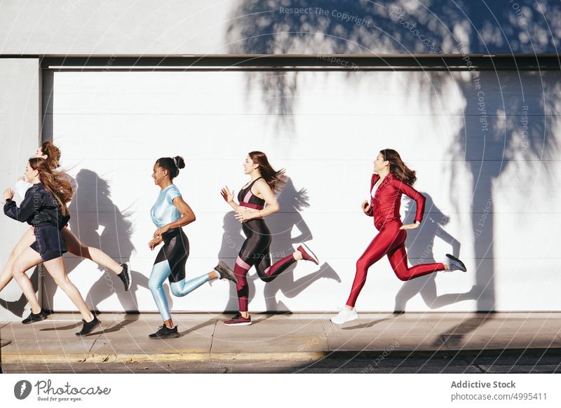 Sportliche, junge, vielseitige Freundinnen laufen auf der Straße Frauen Training positiv Zusammensein Athlet Übung Wohlbefinden Wellness Fitness Sportlerinnen