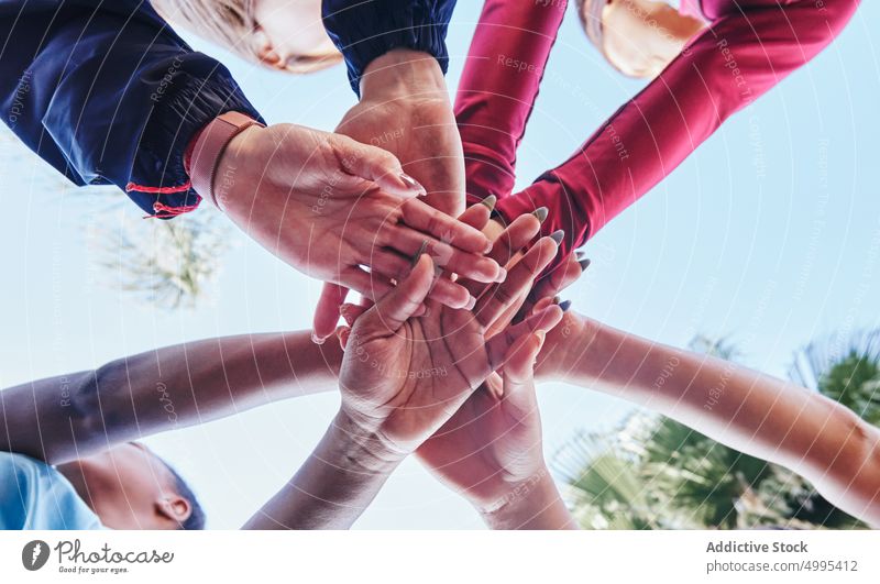 Crop unerkennbar multiethnischen Freunde Stapeln der Hände im Park Frauen Hände stapeln Team beitreten Zusammensein Athlet Training Hände zusammen Blauer Himmel