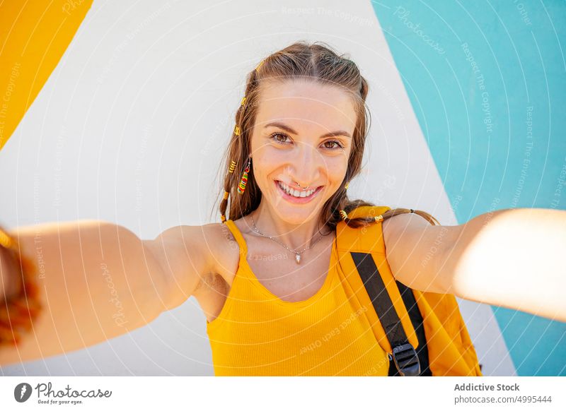Glückliche Frau nimmt Selfie auf der Straße lustig modern urban Stil jung sorgenfrei heiter Rucksack Gedächtnis Tourist Reisender neonfarbig Sommer Moment