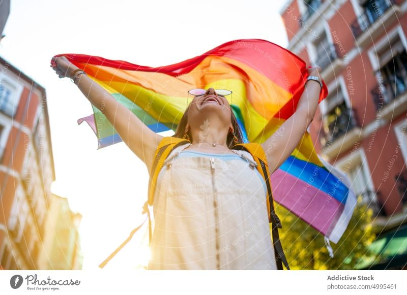 Glückliche junge Frau mit Transgender-Flagge Fahne lgbt Lächeln Straße Stolz abstützen Sommer positiv Optimist Sonnenbrille Top Homosexualität sorgenfrei froh