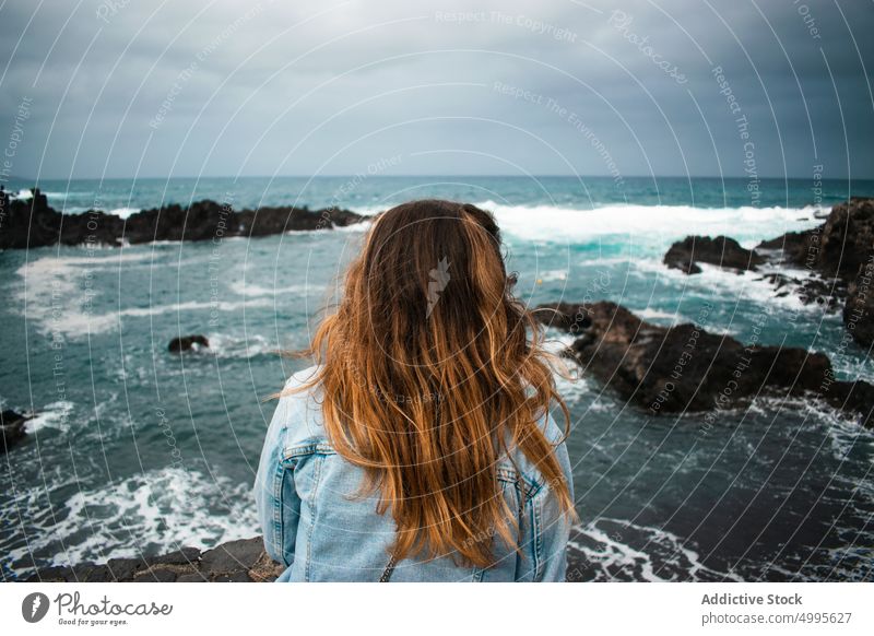 Anonyme Frau bewundert stürmische See bewundern MEER Unwetter winken Klippe Wasser Tourist Wochenende Küste La Palma Kanarische Inseln Spanien lange Haare Natur