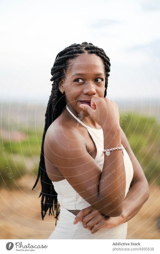 Afroamerikanische Frau, die in die Natur blickt Gesicht berühren Landschaft Sommer Vorschein Stil Porträt Afro-Zöpfe Angebot Erwachsener schwarz Afroamerikaner